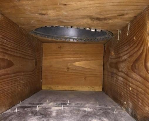 The same air duct after cleaning, bare wood and metal
